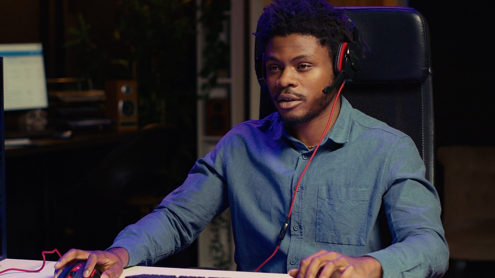 man-playing-intense-game-rgb-lit-computer-desktop-talking-with-fans-livestream-scaled